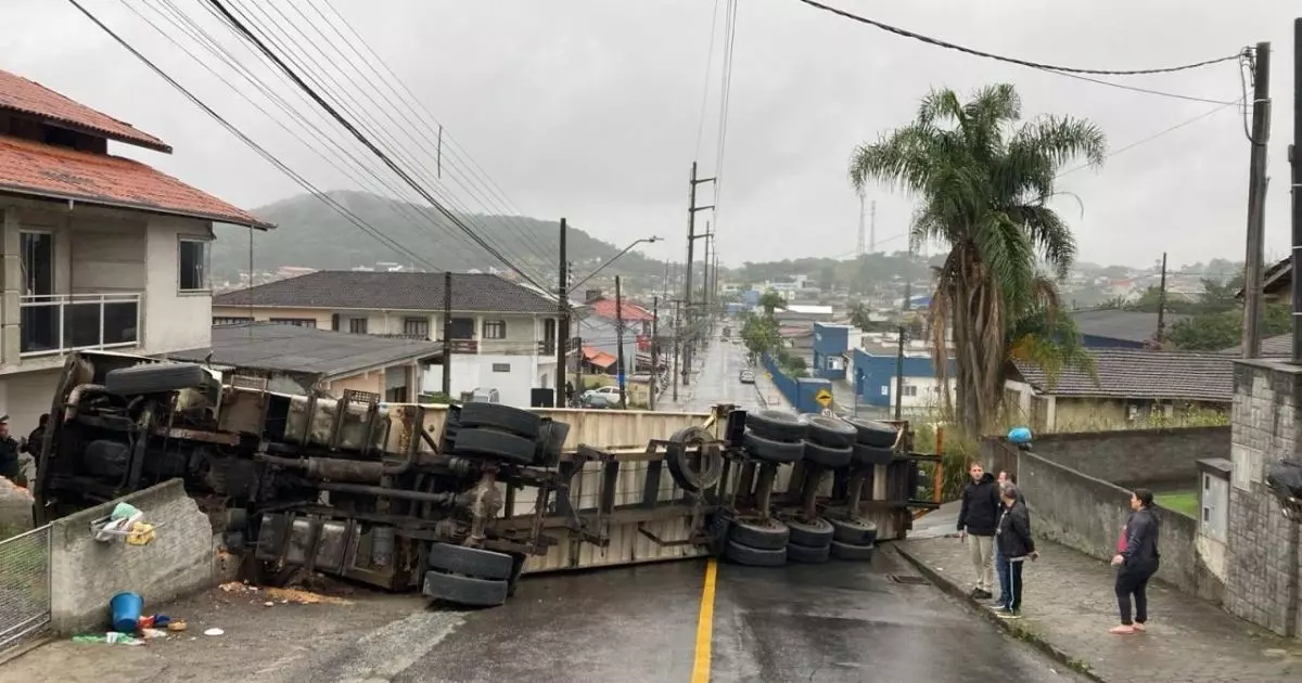 Carreta tomba e atinge muro de casa e poste de energia em Joinville